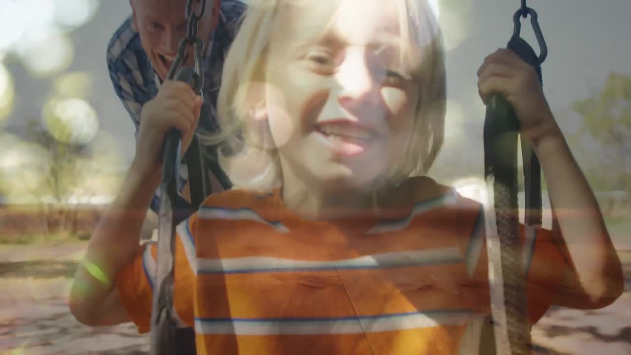 niño balanceándose en un columpio siendo empujado por su padre