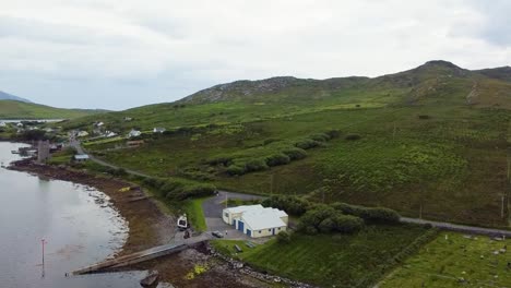 Toma-Aérea-De-Drones-De-Las-Colinas-Y-La-Costa-En-La-Estación-De-Botes-Salvavidas-En-Achill-Sound-Achill-Island-Donde-Se-Filmó-El-Galardonado-Banshees-De-Inisherin