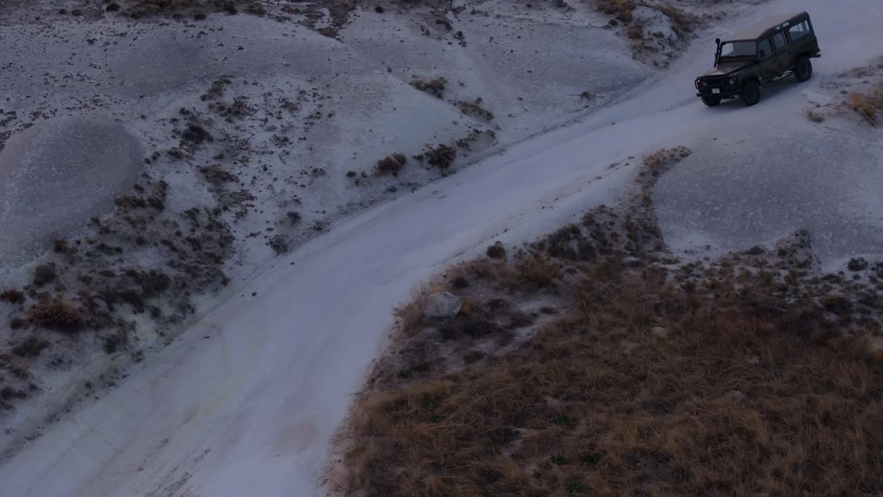 Vista da drone di convoglio 4x4 su sentiero panoramico in valle al crepuscolo, Ortahisar, Turchia.