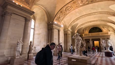 people walking through a sculpture-filled gallery