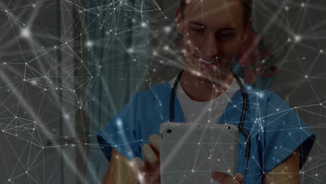 doctor wearing scrubs holding tablet in clinic, network overlay lines floating across screen