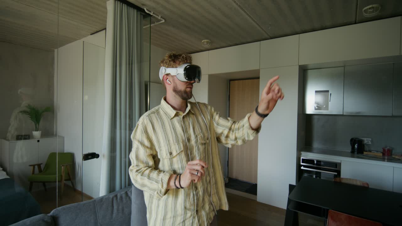 Uomo che usa un visore VR in un appartamento moderno