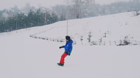 Male-snowboarder-rides-on-a-Board-in-the-snow-from-the-ski-slope-in-slow-motion