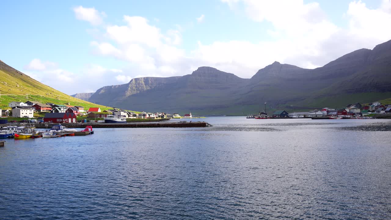 Panning left shot of fjord revealing Hvannasund port and village, Vidoy