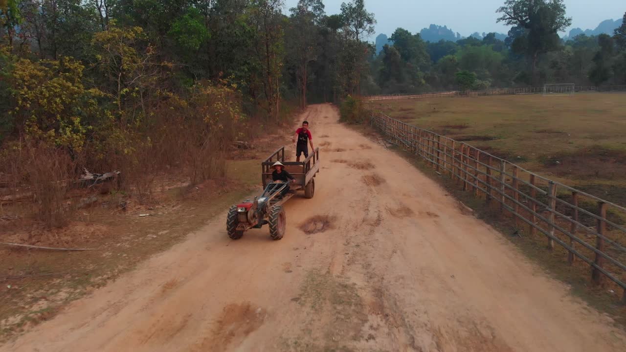 Abitanti di Thakhek con trattore su strada sterrata, Laos