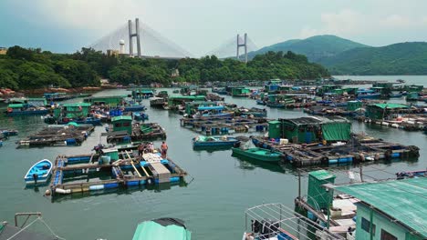 Aerial-over-the-fishing-boats-and-rafts-of-the-fish-farms-on-Ma-Wan-island,-Hong-Kong,-China