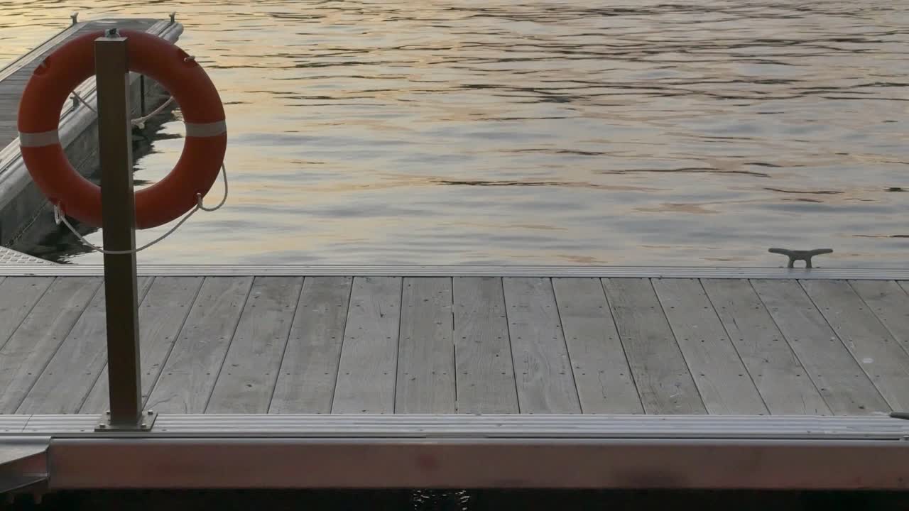 Floating wooden dock with life preserver rocks gently in Perth