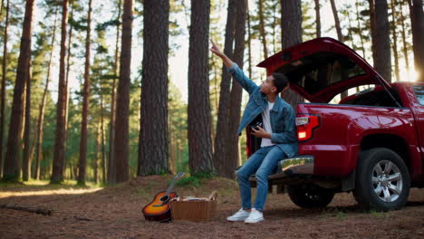 teenager enjoying a picnic in the forest with a red truck