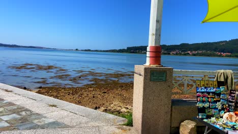 Seaside-souvenir-market-in-promenade-of-la-Toja-island-of-Galicia-at-a-sunny-day,-Spain