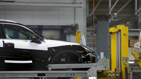 coche de lujo negro en la línea de ensamblaje en una fábrica industrial, interior brillante