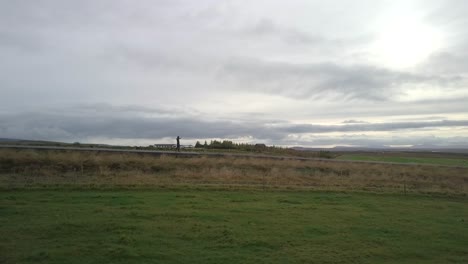 drone shot of a skateboarder cruising down the road in iceland on a cloudy day