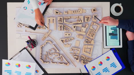 arquitectos con prototipos de edificios trabajando en la mesa de la oficina