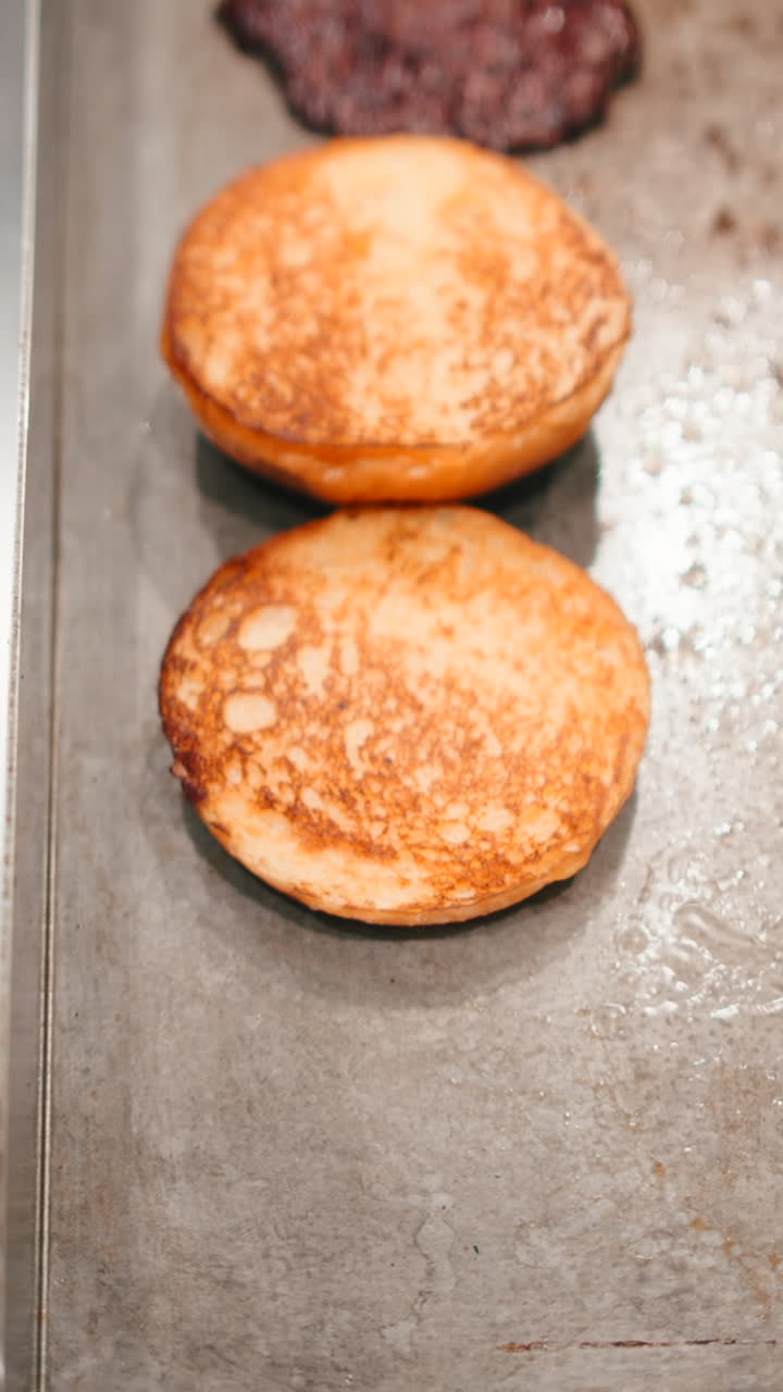 Burger buns and beef on a grill