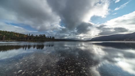 Wolken-Ziehen-Schnell-Vorbei-Und-Spiegeln-Sich-In-Der-Spiegelglatten-Oberfläche-Des-Flachen-Sees-Mit-Klarem,-Transparentem-Wasser