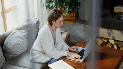 mujer trabajando en una computadora portátil en casa