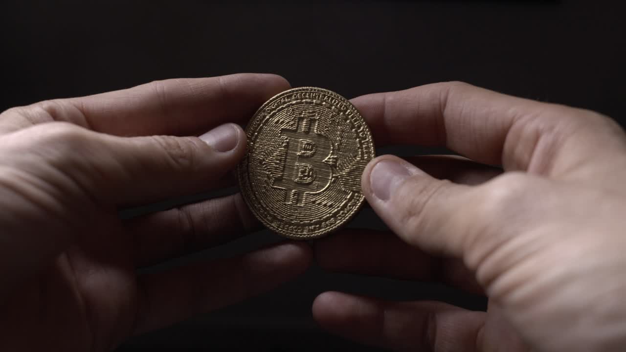 Two hands holding Crypto currency Gold Bitcoin - BTC - Bit Coin. Macro shots.