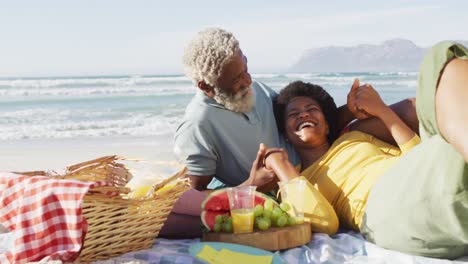 Feliz-Pareja-Afroamericana-Haciendo-Un-Picnic-En-La-Playa-Soleada