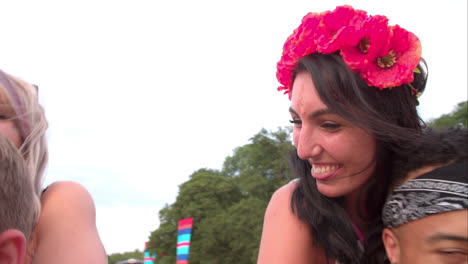 Young-friends-piggy-backing-at-a-music-festival,-close-up