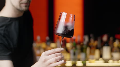 bartender holding a glass of red wine