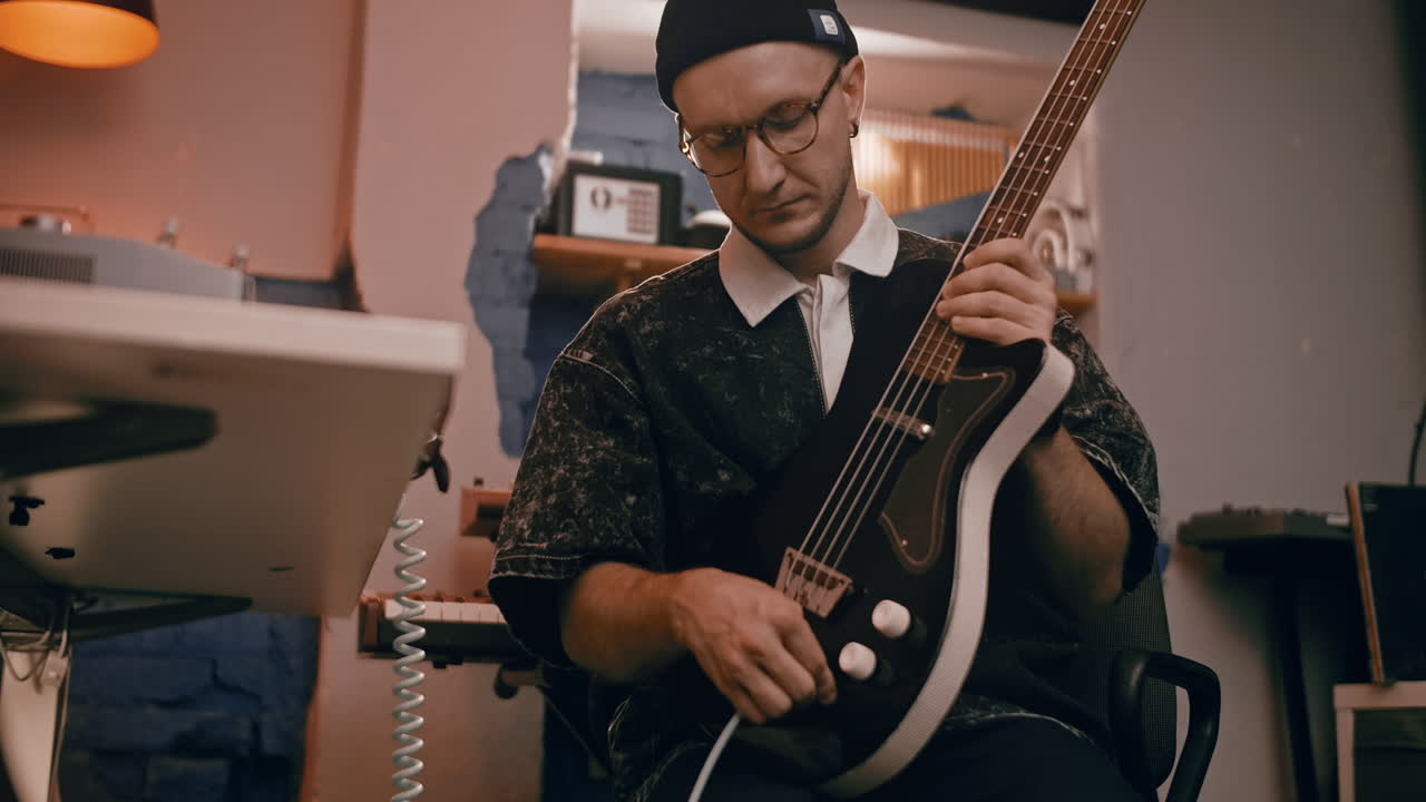 Musician Playing Bass Guitar in a Recording Studio