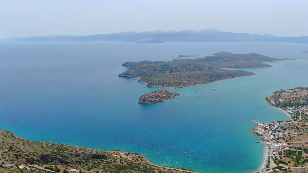 vista de pájaro que muestra un mar tranquilo y pacífico rodeado de acantilados y montañas en una isla deshabitada