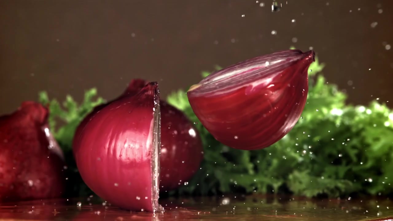 Red Onion Cut in Half with Water Splashing in Slow Motion