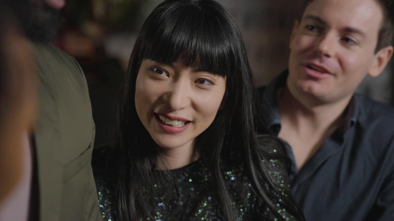 кадр отслеживания друзей, разговаривающих и смеющихся в баре