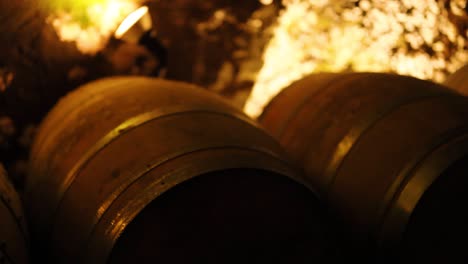 rows of barrels in a dimly lit cellar