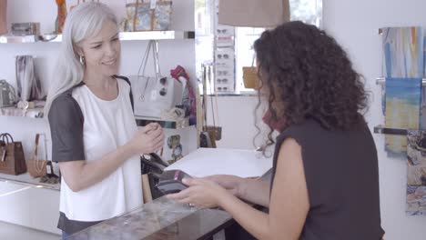 amable cliente femenino pagando por la compra