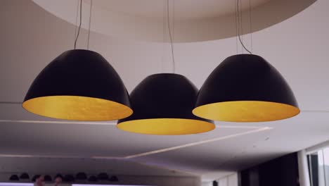 trío de lámparas colgantes modernas con interior dorado en una casa de lujo