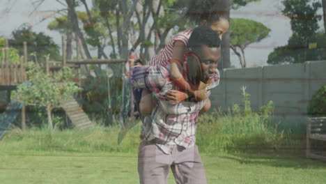 in sunny park, father carrying child on shoulders while enjoying animation