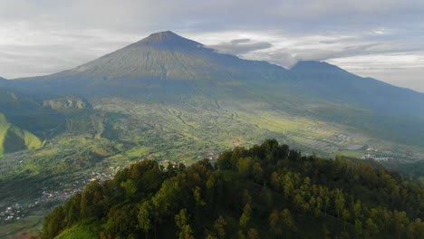 aerial view move away shot, pergasinan hill trees, mount rinjani in the background