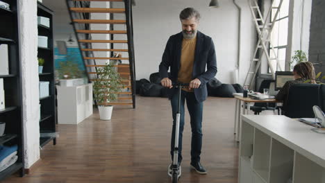 man riding electric scooter in office