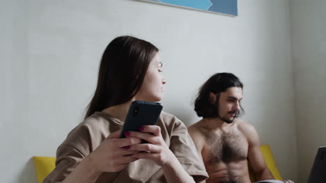 woman using smartphone on bed