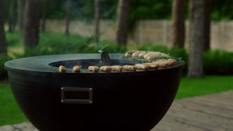 side view on bowl grill outside. meat sticks grilling on grill for bbq party