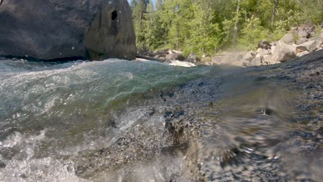 Vista-De-ángulo-Bajo-Del-Agua-Del-Río-Corriendo-Sobre-La-Roca