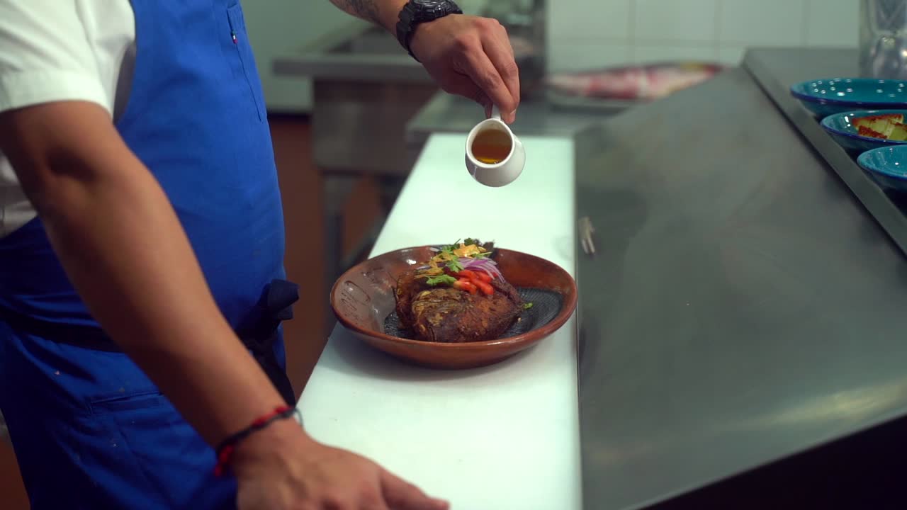 Chef seasoning addressing fish with olive oil fried  slo motion latin