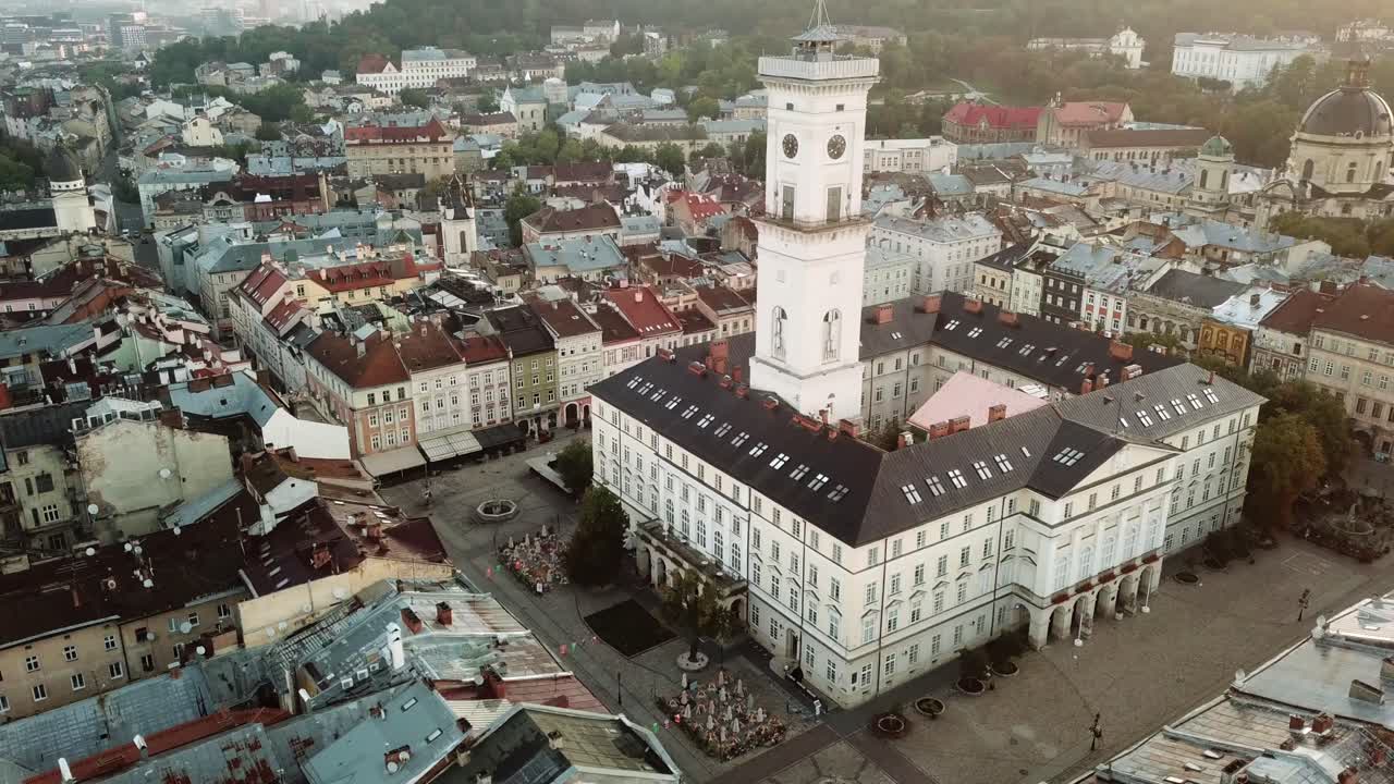 Ukraine, Lviv, City Hall,Clock Tower and Rynok Square during sunset, drone footage turns around the clock tower with a perfect angle, beautiful city view around the tower,empty square almost no people