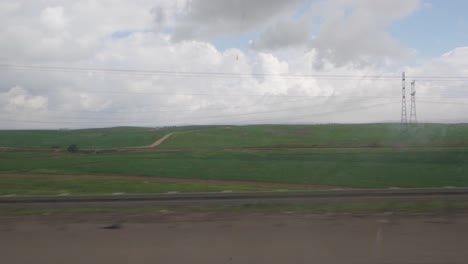 a long, empty road with a power line tower in the background