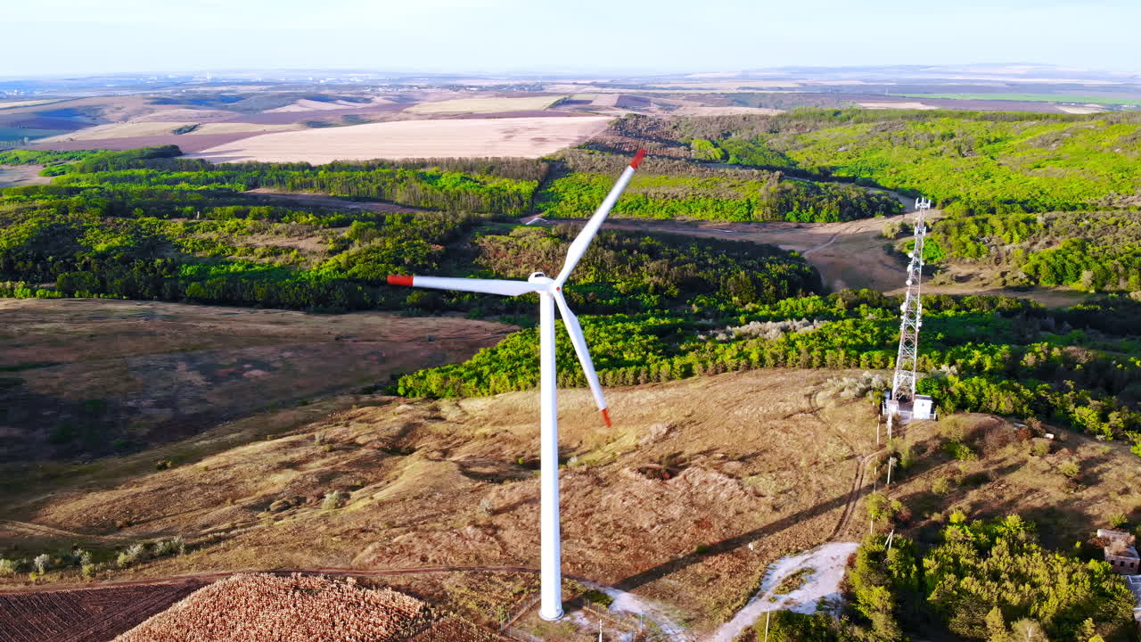 Aerial drone view of wind turbines for energy production located on a field at sunset. Windmill's power generating clean renewable energy for sustainable development. Balti, Moldova