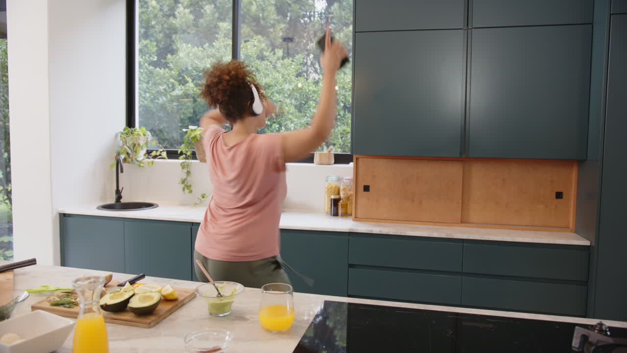 Preparazione di un pasto sano, donna con le cuffie che taglia le verdure in una cucina moderna, spazio per il testo.