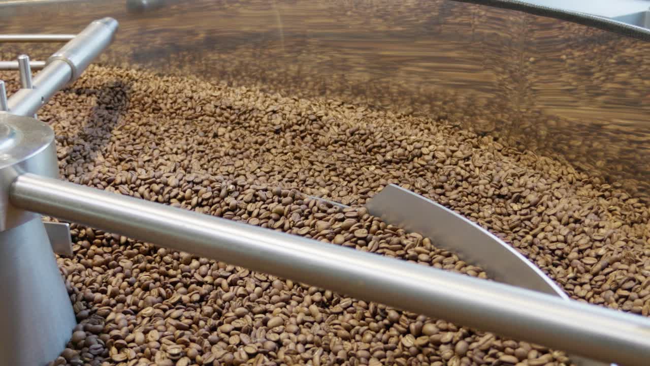 Witness the intricate mixing process of coffee beans in a roasting facility.
