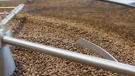 witness the intricate mixing process of coffee beans in a roasting facility.