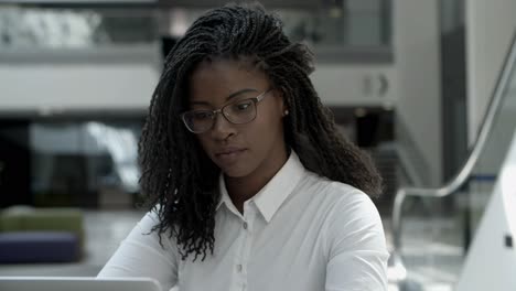 concentrated young businesswoman looking at laptop