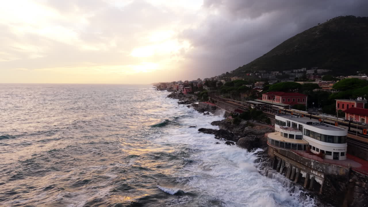 Drone aereo sorvola il mare mosso e la città costiera di Genova, in Italia, durante l'ora d'oro, paesaggio