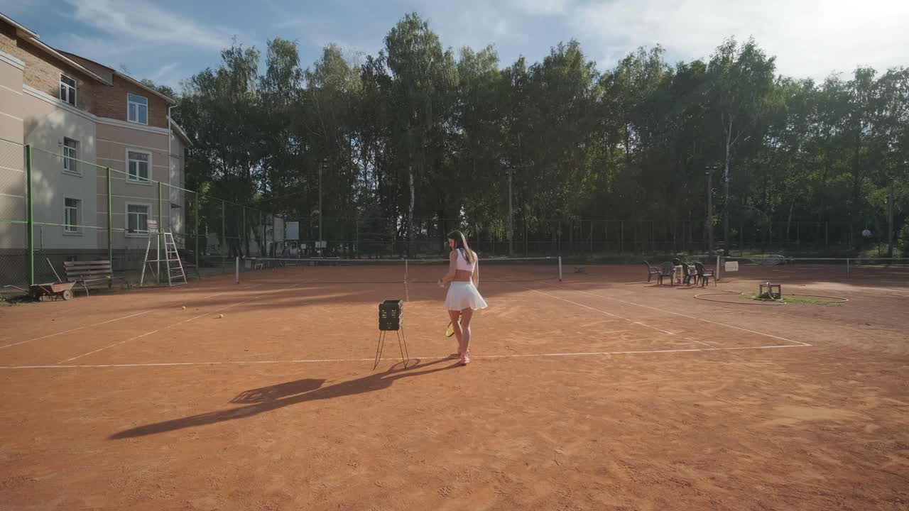 여자 테니스 선수 가 야외 코트 에서 세브 를 연습 하고 있다