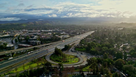 aerial view of cityscape, drone panning left above highway, ecocity panoramic view