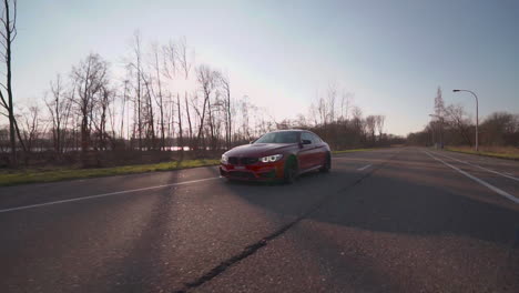 Coche-Rojo-Conduciendo-Por-Una-Carretera