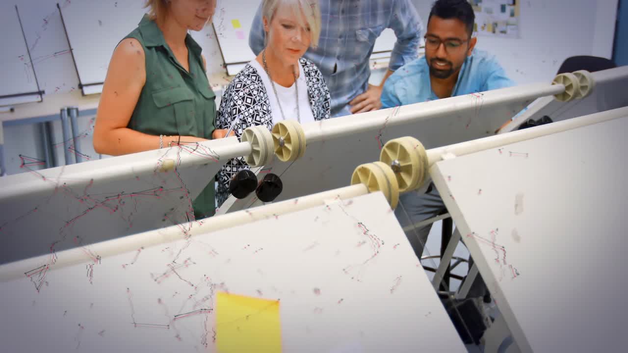 architect examining tilted drafting table in studio with yellow sticky note, blueprint icons