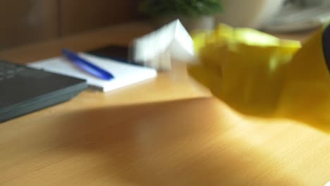 person in yellow gloves cleaning a desk